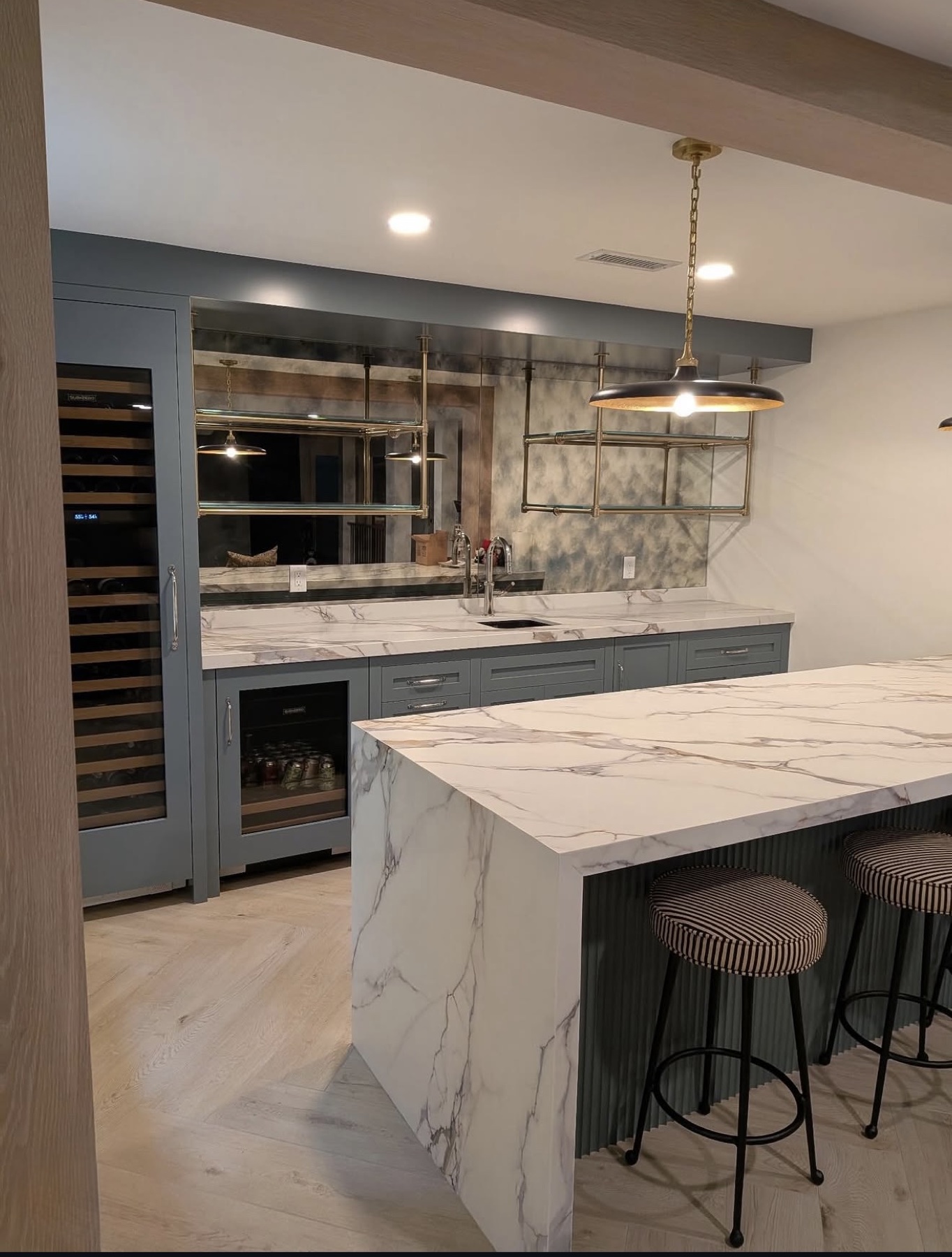 Custom blue-gray home bar with marble island in Massachusetts